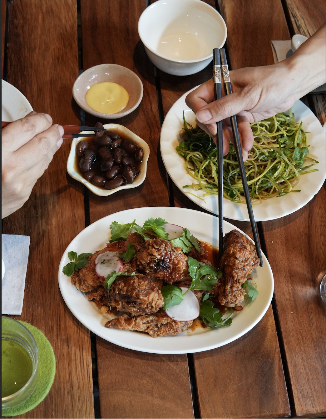 Pollo frito de Makan con palillos sobre mesa de madera
