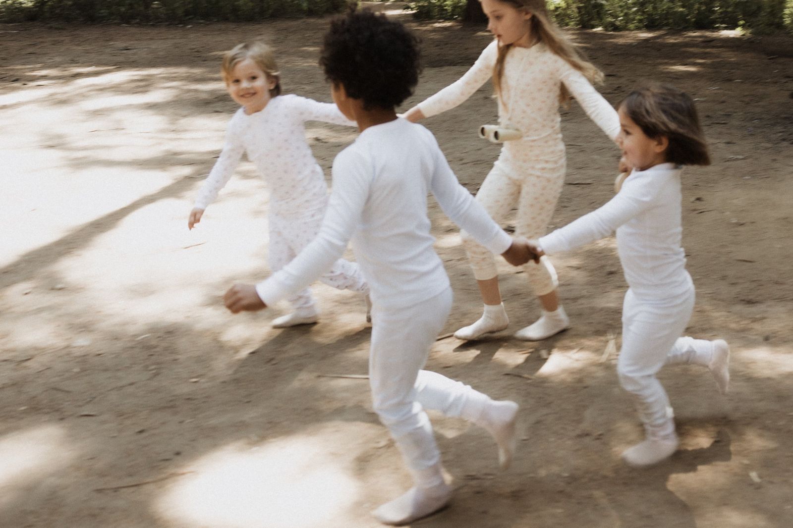 Niños con pijamas Nonoy jugando a la ronda en el bosque