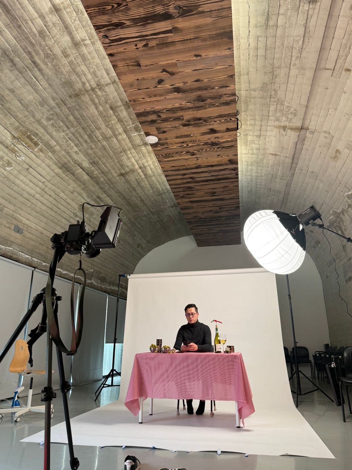 Set de fotografía con cámara, luz y mesa con mantel rosa